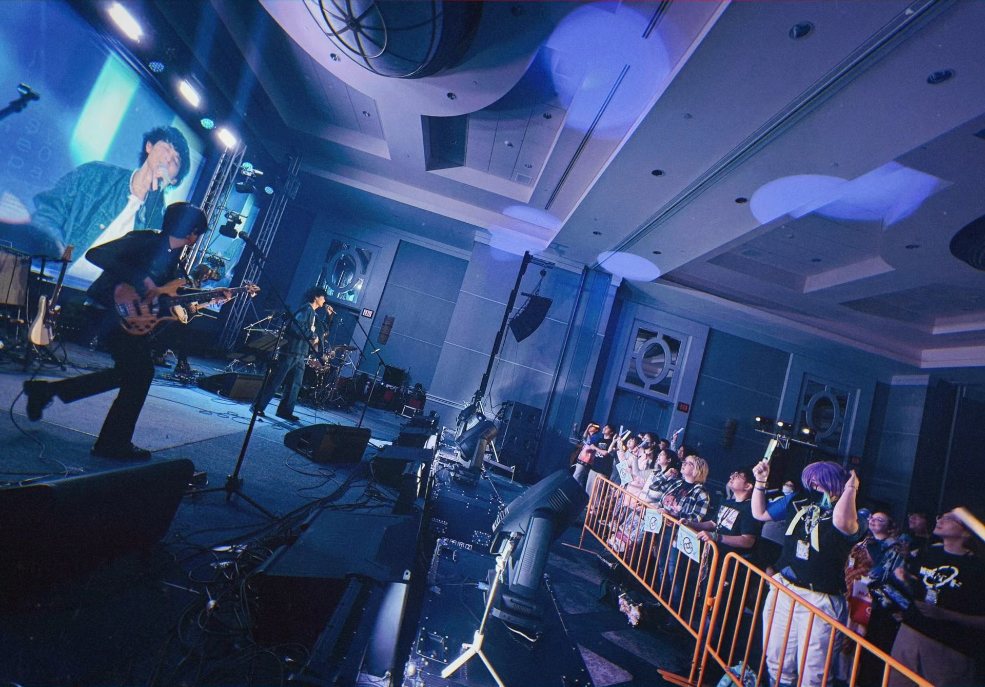 Guitarist performing beside an engaged Anime Otapia audience